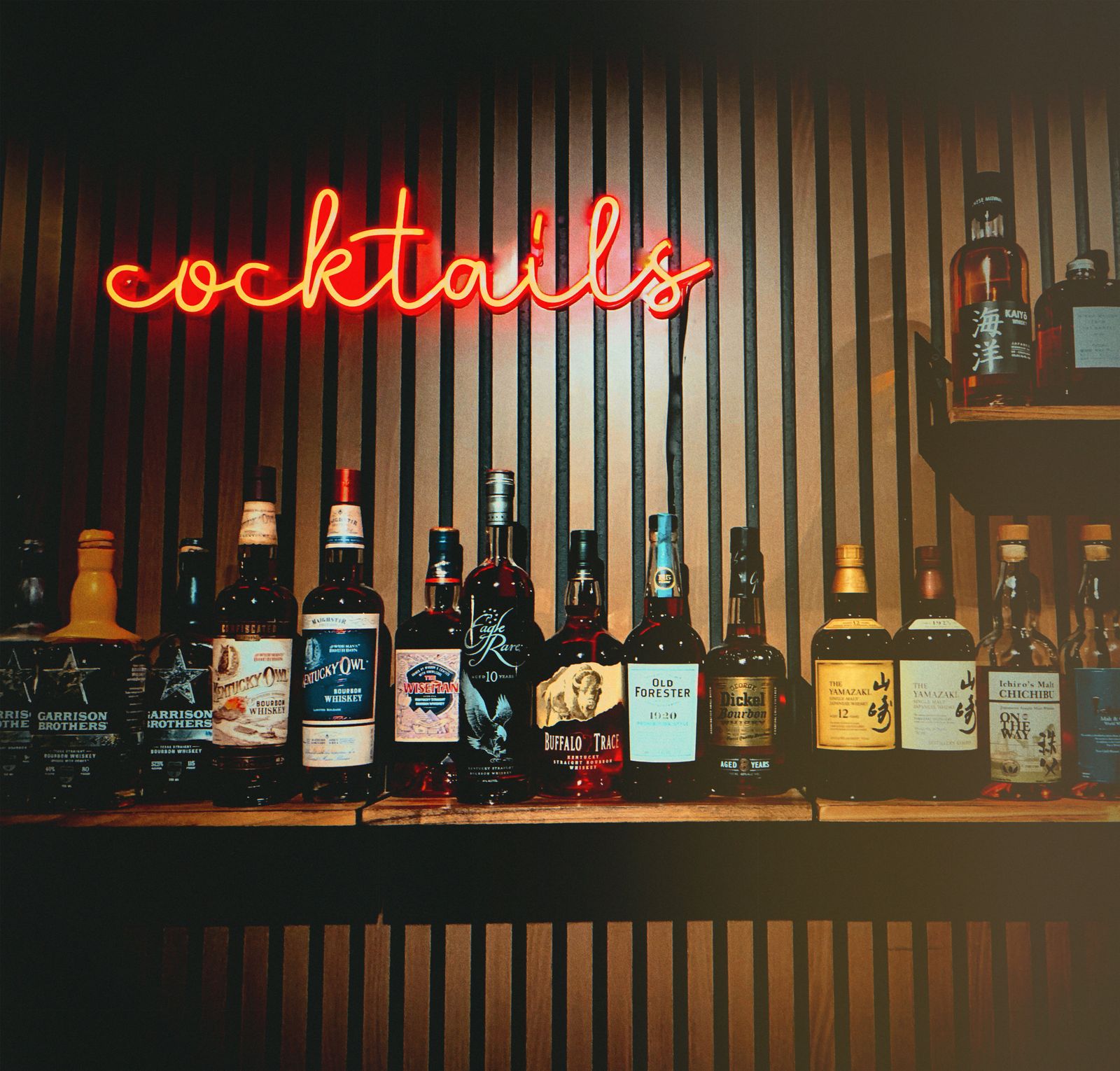 The neon cocktails sign above Lucky Duck's whiskey collection