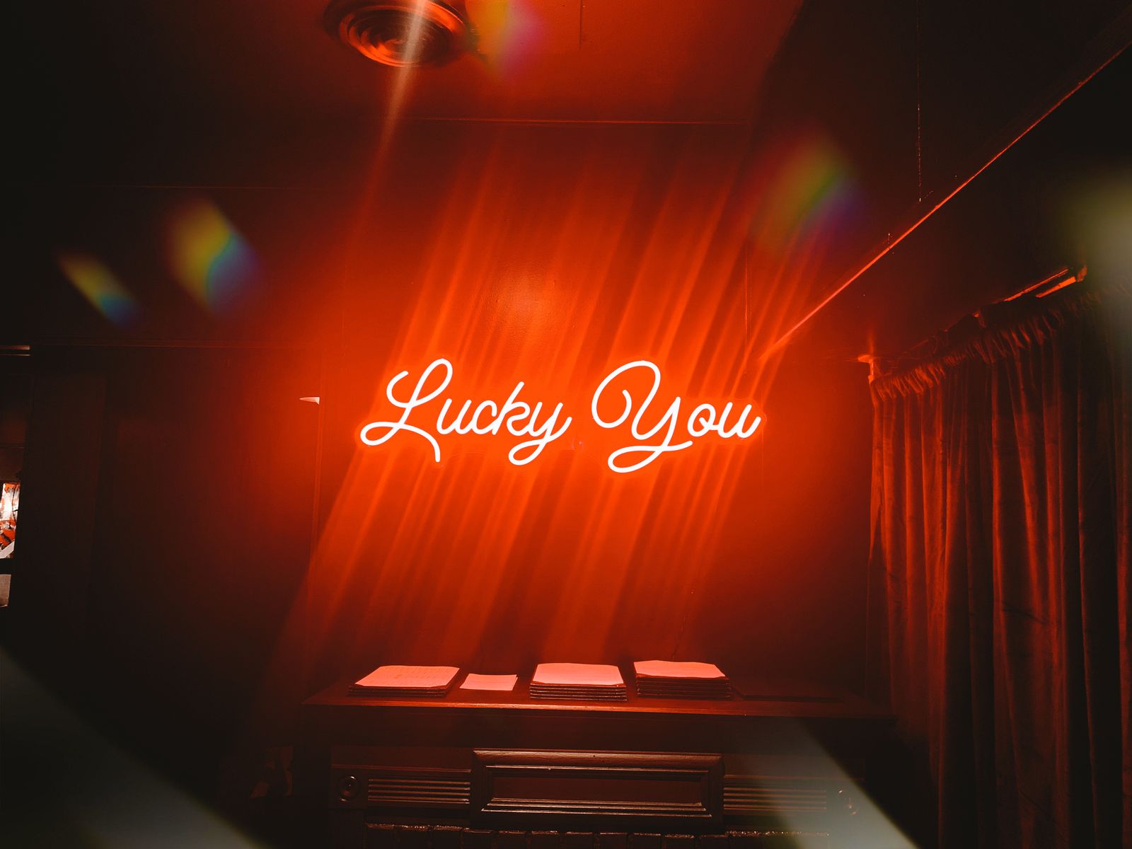 The Lucky You neon sign installation glowing red at Lucky Duck